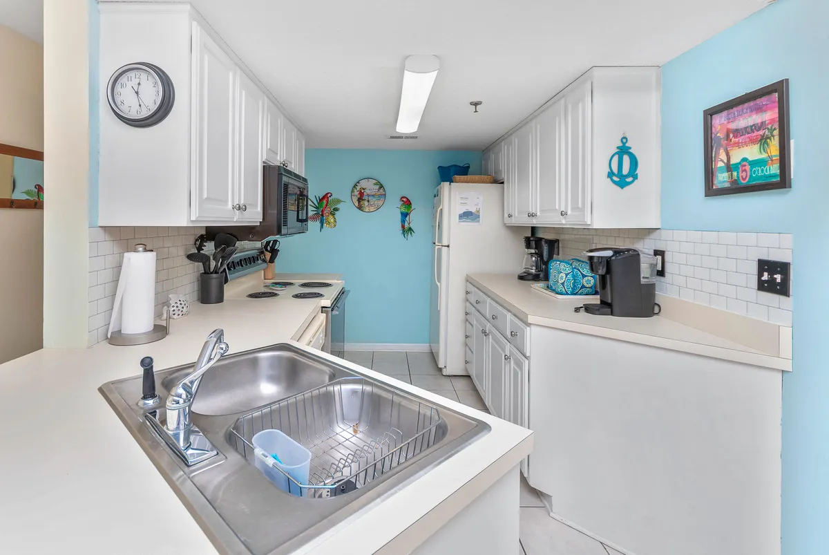 A well-equipped kitchen featuring modern appliances, generous counter space, and vibrant decorative wall art. The kitchen is staged for cooking and entertaining, hinting at bustling activity as families and friends prepare meals together.
